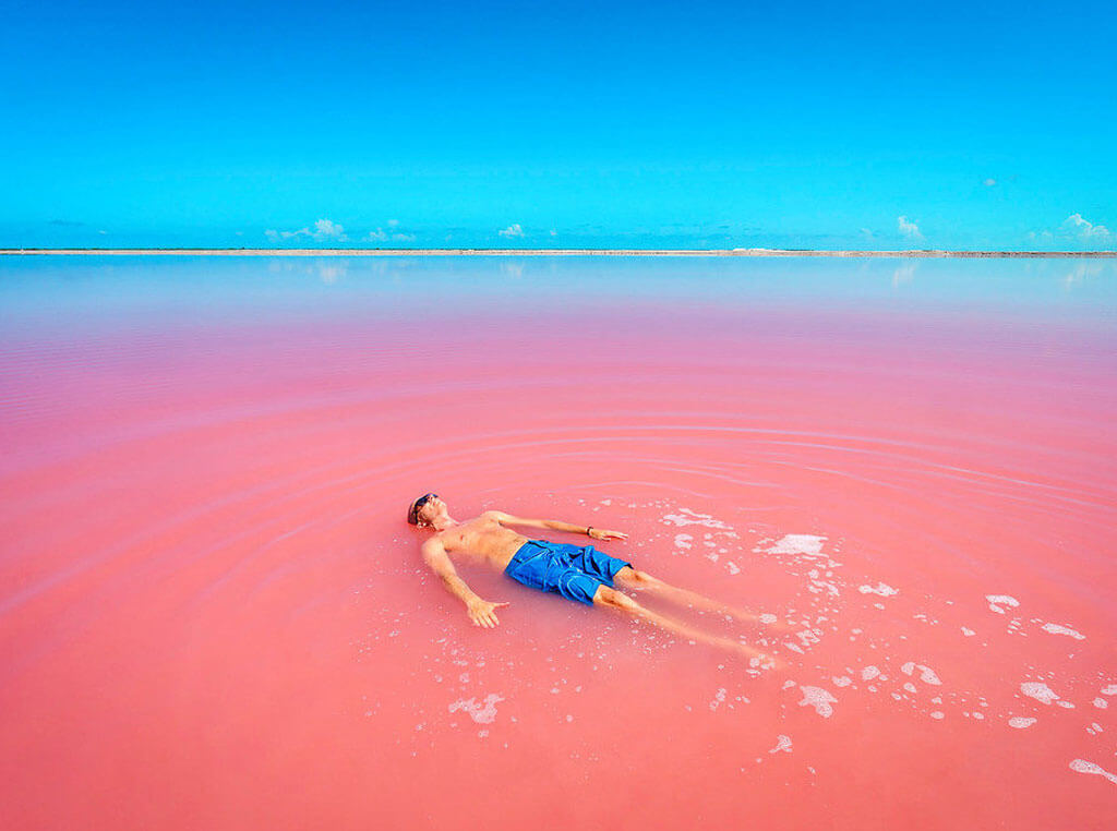 Man floating in pink lagoon near Río Lagartos
